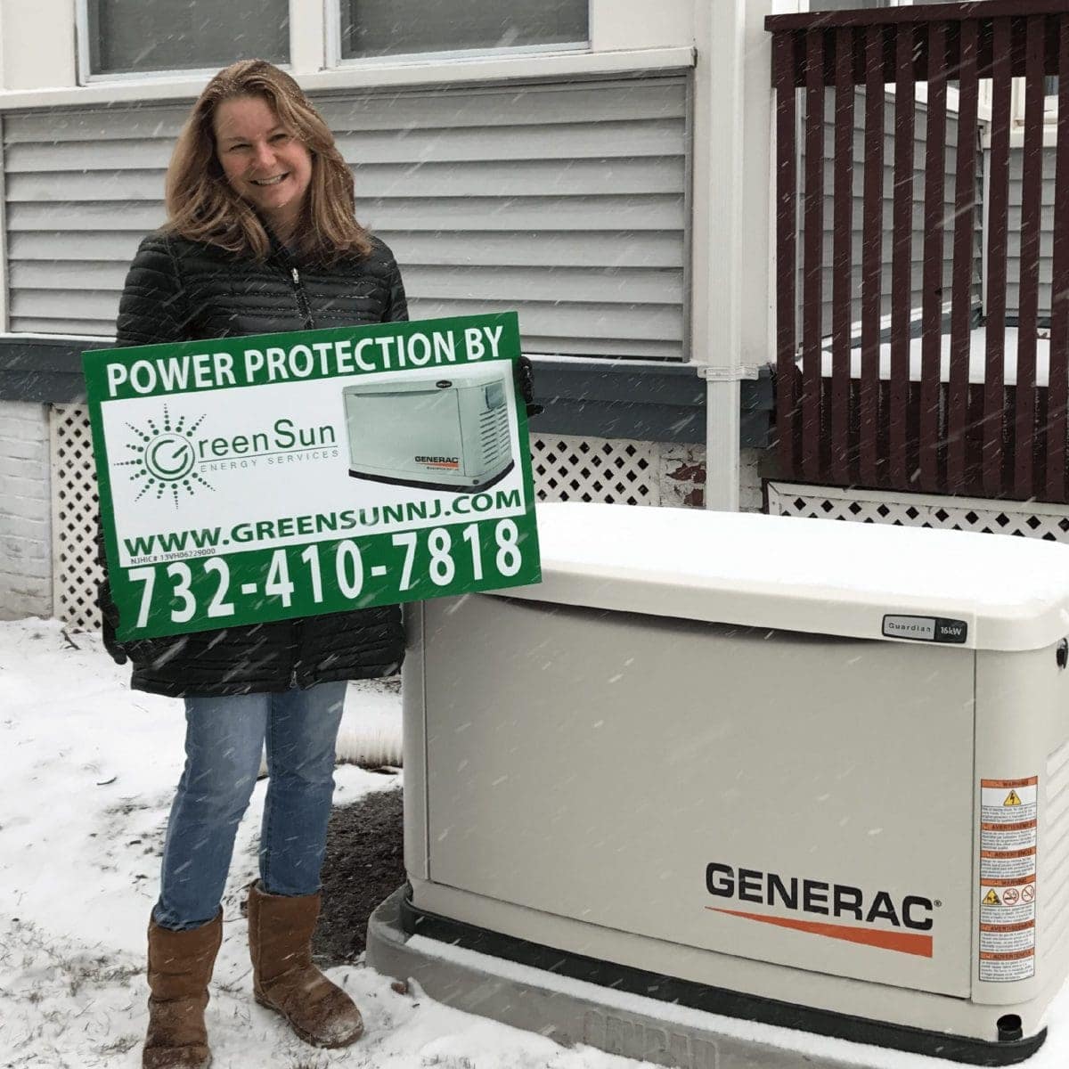 Avon-by-the-Sea, NJ homeowner holding a Green Sun Energy Services sign next to a Generac standby generator installed and maintained by Green Sun Energy Services, LLC