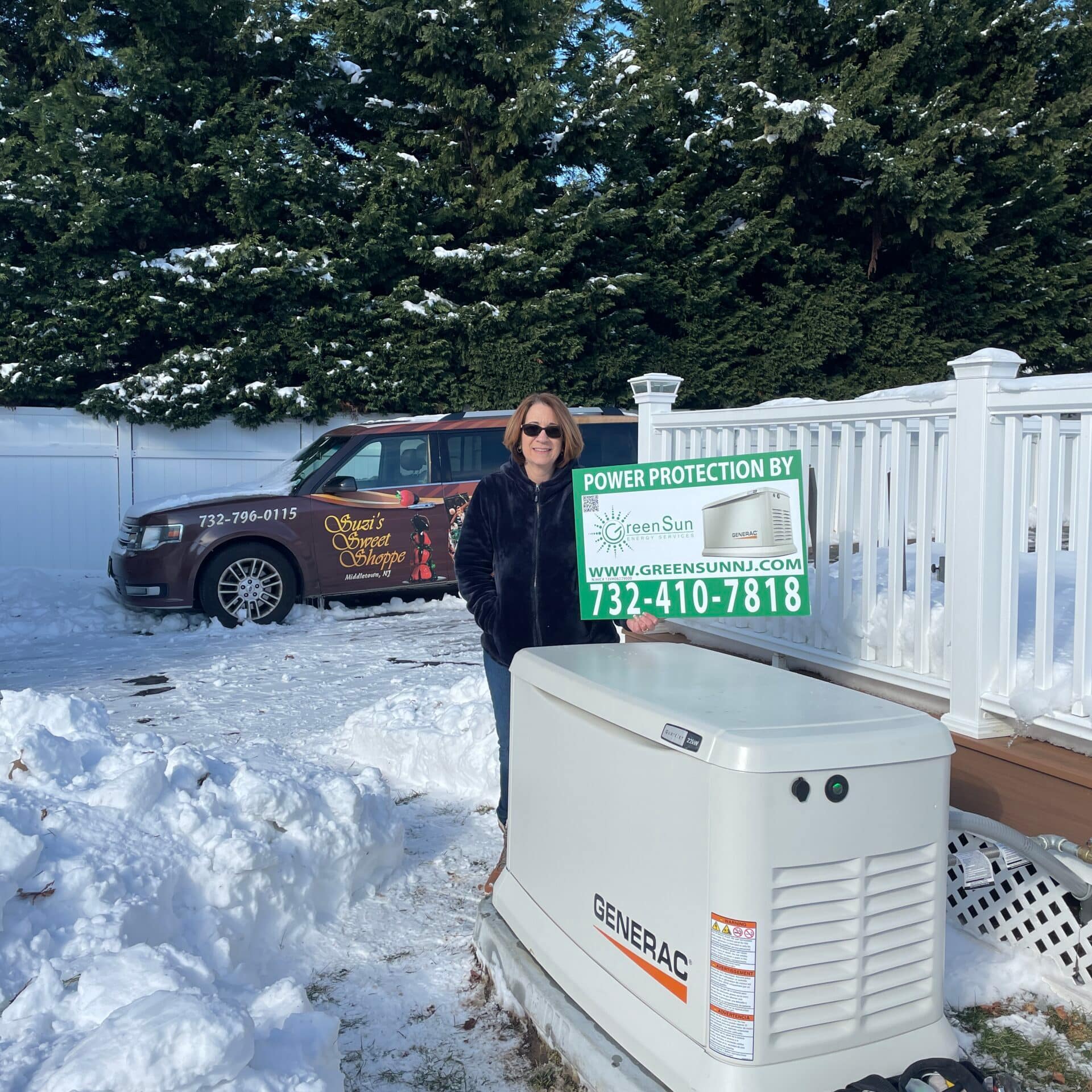 Client holding Green Sun Energy Services, LLC lawn sign near their newly installed Generac home standby generator in Middletown NJ