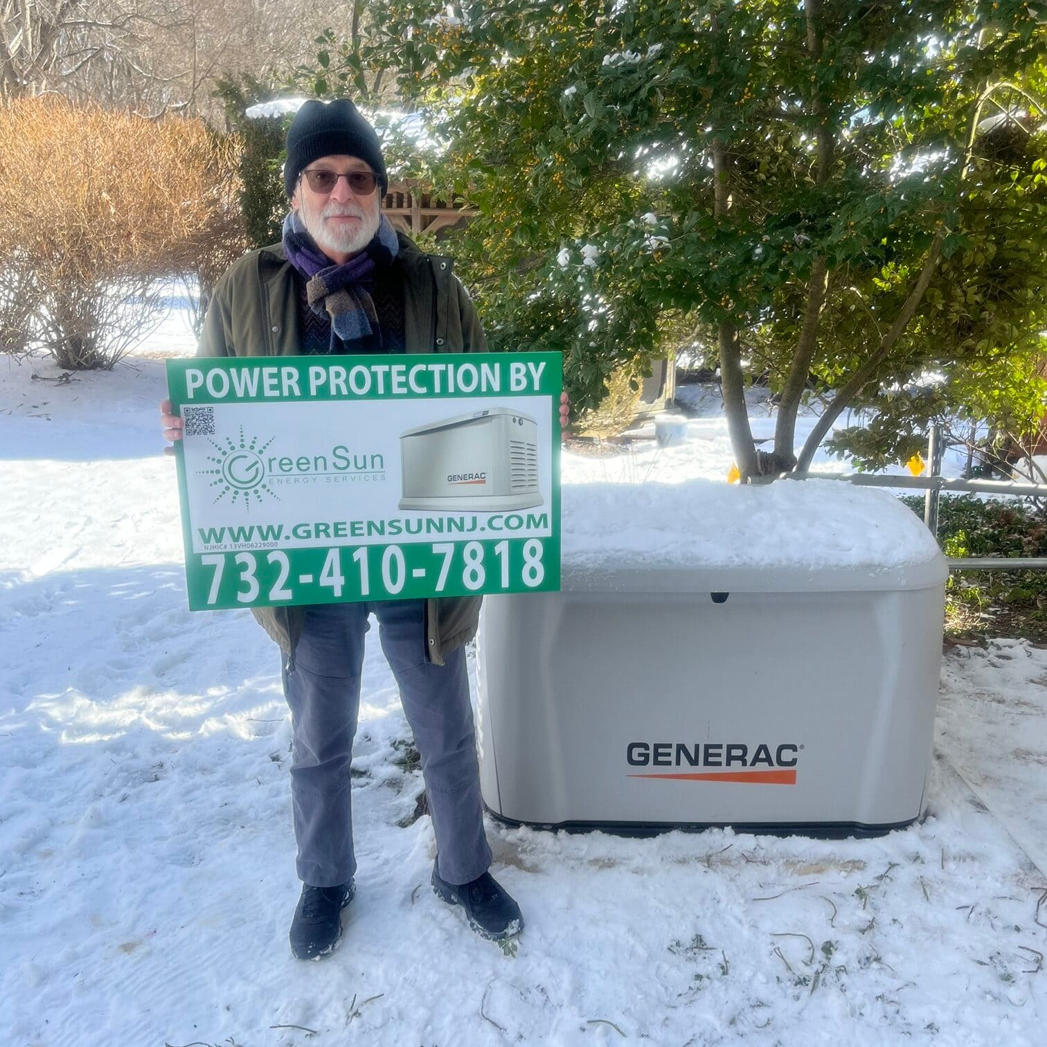 Client holding Green Sun Energy Services, LLC lawn sign next to newly installed Generac whole-home standby generator in Roosevelt, New Jersey
